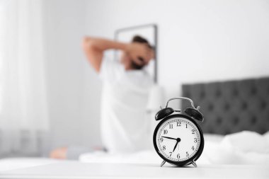 Analog alarm saat ve arka plan üzerinde bulanık adam. Günün saati