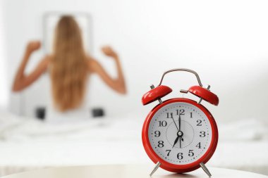 Analog alarm saat ve arka plan üzerinde bulanık kadın. Günün saati