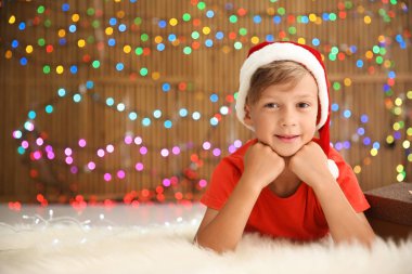 Noel Baba şapkası bulanık ışıklar karşı katta yalan şirin küçük çocuk. Noel kutlamaları
