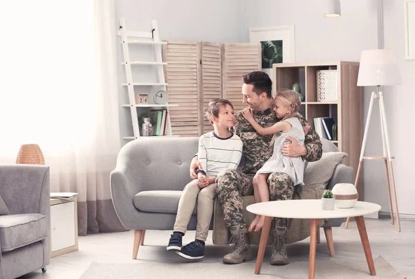 Onun çocukları evde kanepe ile askeri üniformalı genç adam