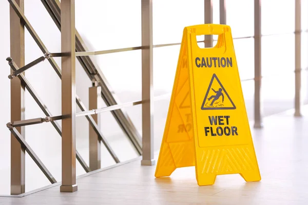 Safety sign with phrase Caution wet floor, indoors. Cleaning service