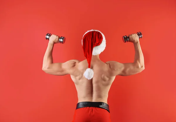 Young Muscular Man Santa Hat Dumbbells Color Background — Stock Photo, Image