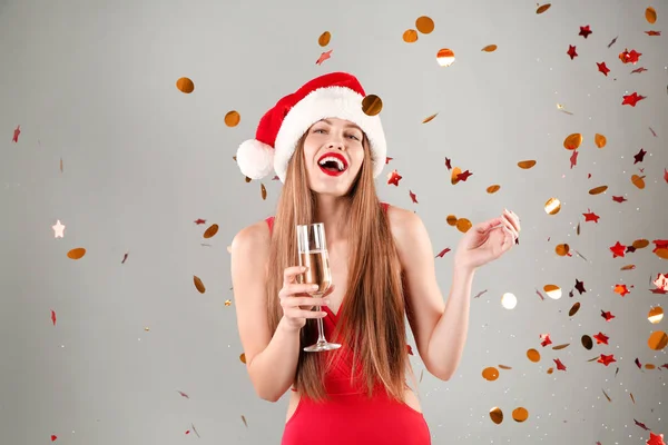 Noel Baba Şapkası Mayo Şampanya Gri Arka Plan Üzerinde Tutan — Stok fotoğraf