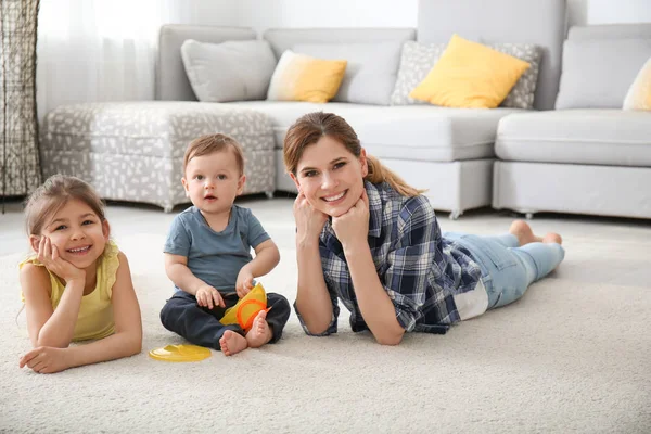 Moeder Met Schattige Kleine Kinderen Liggen Gezellige Tapijt Thuis — Stockfoto