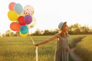 Renkli balonlar alanında güneşli olan kadın