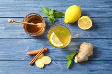 Fincan sıcak çay, limon ve zencefil ahşap masa, üstten görünüm soğuk için