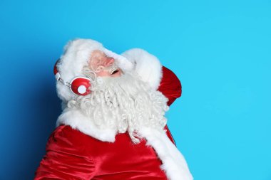 Otantik Noel Baba renk arka plan üzerinde müzik dinlemek