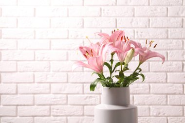 Tuğla duvar yakınındaki güzel çiçek açan lily çiçekler