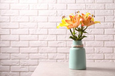 Tuğla duvar yakınındaki güzel çiçek açan lily çiçekler