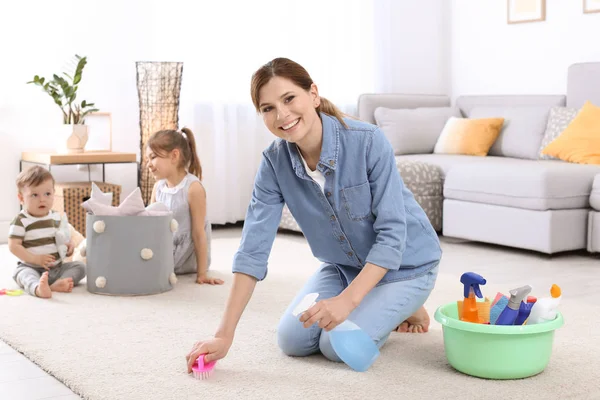 Housewife Cleaning Carpet While Her Children Playing Room — Stock Photo, Image