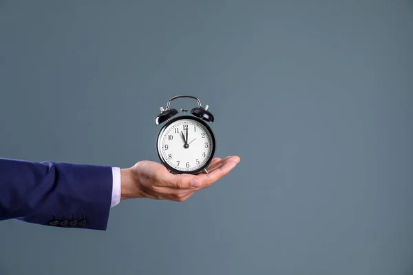 Jovem Empresário Segurando Relógio Fundo Cor Gestão Tempo — Fotografia de Stock