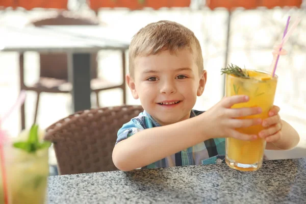 Doğal limonata kafede masada bir bardak ile sevimli çocuk