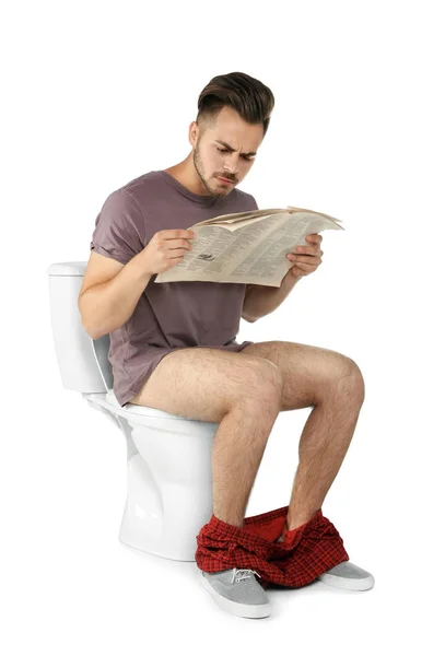 Joven Leyendo Periódico Mientras Está Sentado Inodoro Aislado Sobre Blanco — Foto de Stock