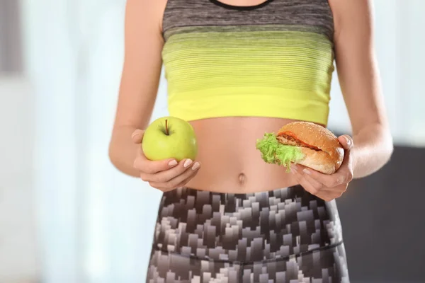 Kobieta Trzyma Smaczne Kanapki Świeże Jabłka Pomieszczeniu Wybór Pomiędzy Dietą — Zdjęcie stockowe
