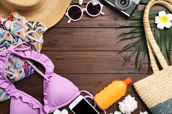 Tahta zemin üzerinde plaj nesneleri ile düz kompozisyon yatıyordu