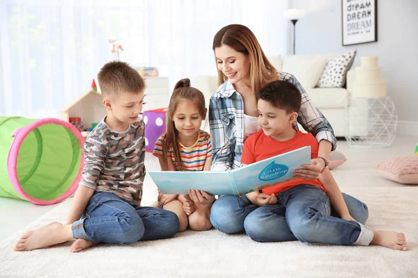 Bonito Crianças Lendo Livro Chão Com Jovem Mãe Sala Jogos — Fotografia de Stock