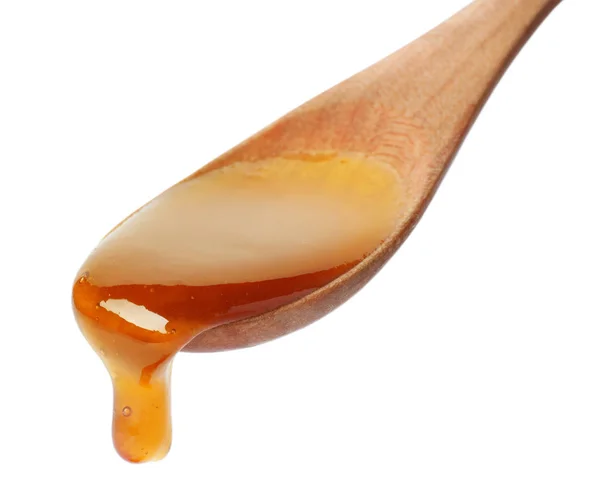 白い背景の上のスプーンから滴る蜂蜜 — ストック写真
