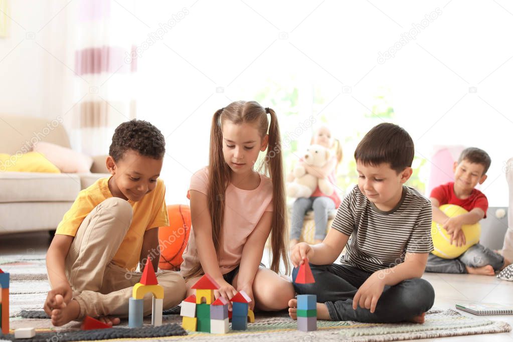 Cute little children playing together indoors