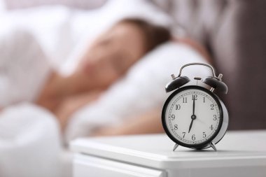 Çalar saat tablo ve kadın yatak odasında. Ne zaman uyku