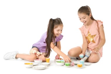 Beyaz arka plan üzerinde çay partisi oyuncakları ile oynarken küçük çocuklar. Kapalı eğlence