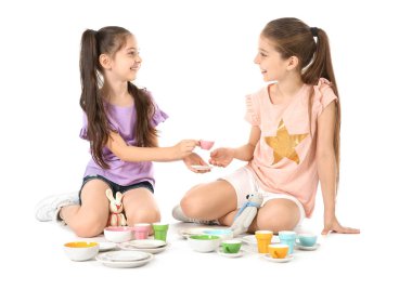 Beyaz arka plan üzerinde çay partisi oyuncakları ile oynarken küçük çocuklar. Kapalı eğlence