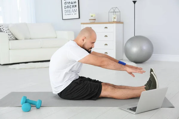 Hombre Con Sobrepeso Haciendo Ejercicio Mientras Tutorial Ordenador Portátil Casa — Foto de Stock