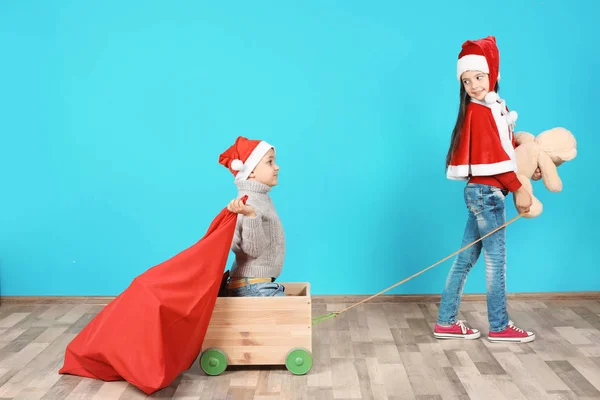 Niedlichen Kleinen Kindern Weihnachtsmützen Spielen Mit Spielzeugwagen Und Weihnachtssack Der — Stockfoto