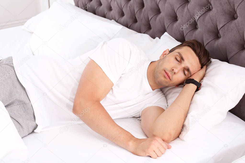 Young man sleeping in bed at home