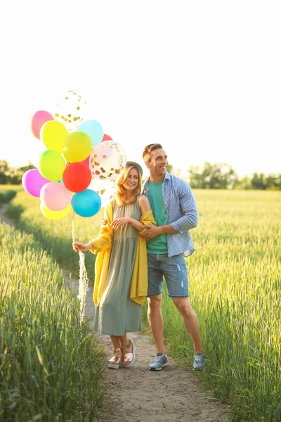 Junges Paar Mit Bunten Luftballons Auf Feld Sonnigem Tag — Stockfoto