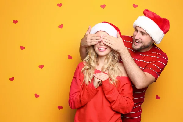 Pareja Joven Sombreros Santa Sobre Fondo Color Celebración Navidad —  Fotos de Stock