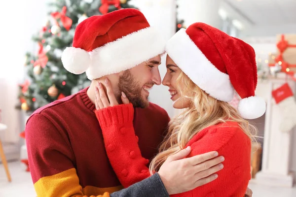 Noel Baba şapkaları Evde Genç çift. Noel kutlamaları