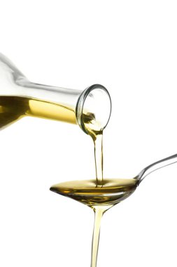 Beyaz zemin üzerine kaşık içine taze zeytin yağ boşaltma