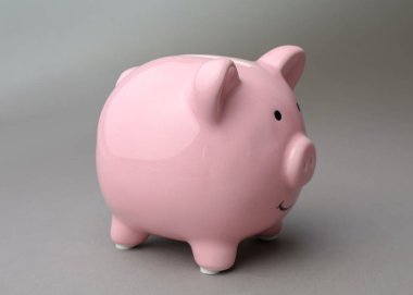 Gri arka plan üzerinde şirin pembe kumbara