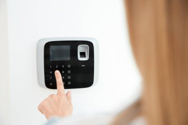 Genç kadın kapalı alarm sistemi tuş takımında kodunu girme