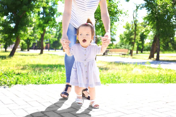 Schattig Babymeisje Moeder Handen Houden Terwijl Het Leren Lopen Buiten — Stockfoto