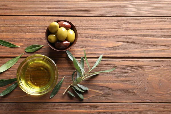 Ahşap arka plan üzerinde taze zeytin yağı ile düz yatıyordu kompozisyon