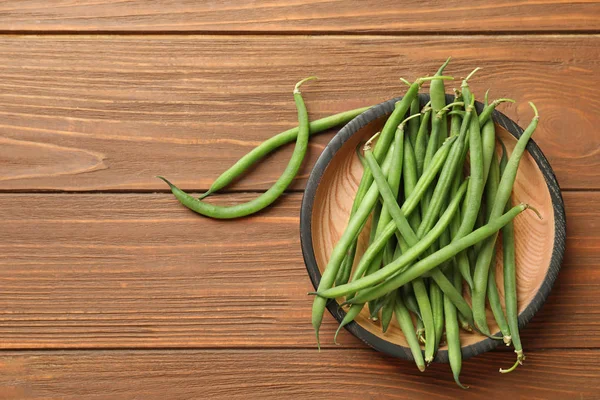 Ahşap masa, üstten görünüm taze yeşil Fransız fasulye ile plaka