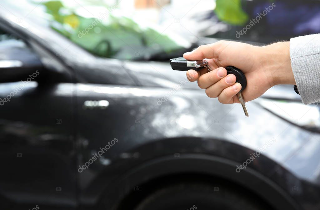Young man using car alarm system outdoors