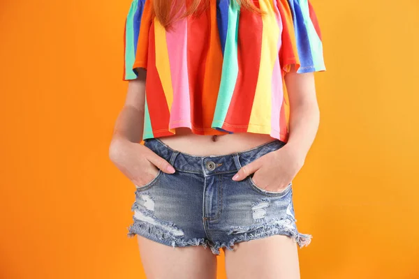 背景色のスタイリッシュなデニム ショート パンツの若い女性 — ストック写真