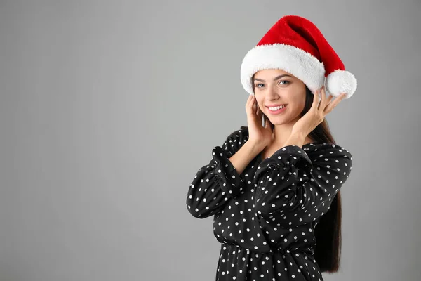 Νεαρή Όμορφη Γυναίκα Στο Καπέλο Santa Γκρι Φόντο Χριστουγεννιάτικη Γιορτή — Φωτογραφία Αρχείου