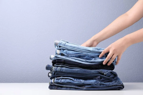 Young Woman Folding Stylish Jeans Table — Stock Photo, Image