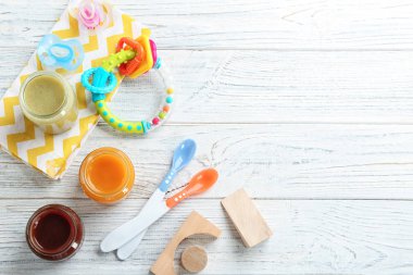Bebek maması ve aksesuar ahşap arka plan üzerinde düz yatıyordu kompozisyonu