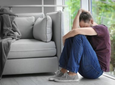 Yalnız depresif adam evde pencere yakınındaki