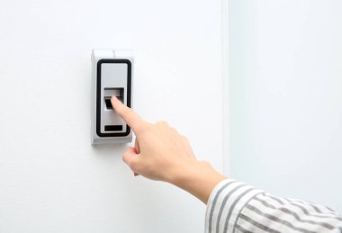 Genç kadın kapalı korku sistem üstünde parmak izi tarayıcı tuşuna basarak