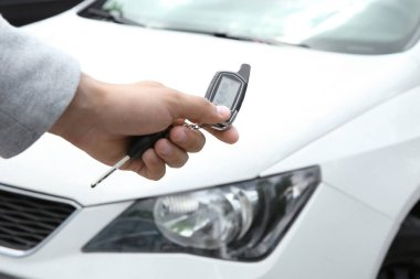 Genç adam açık havada araba alarm sistemi kullanarak