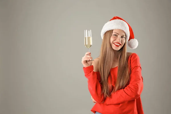Noel Baba Şapkası Ile Şampanya Gri Arka Plan Üzerinde Genç — Stok fotoğraf
