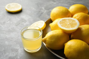 Olgun limon ve bardak taze meyve suyu masada ile plaka