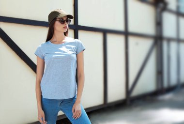 Sokakta gri t-shirt giyen genç kadın. Kentsel tarzı