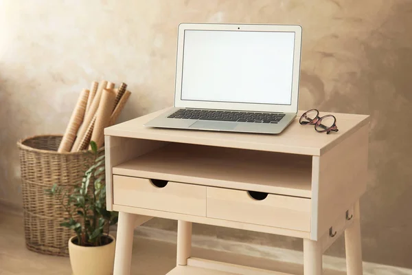 High wooden table with laptop as stand up workplace in modern interior