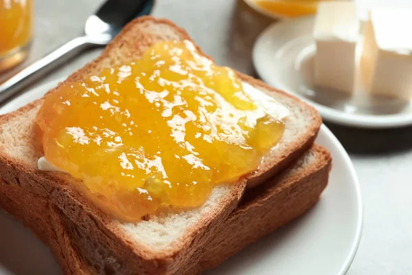 Toast bread with sweet jam on plate, closeup